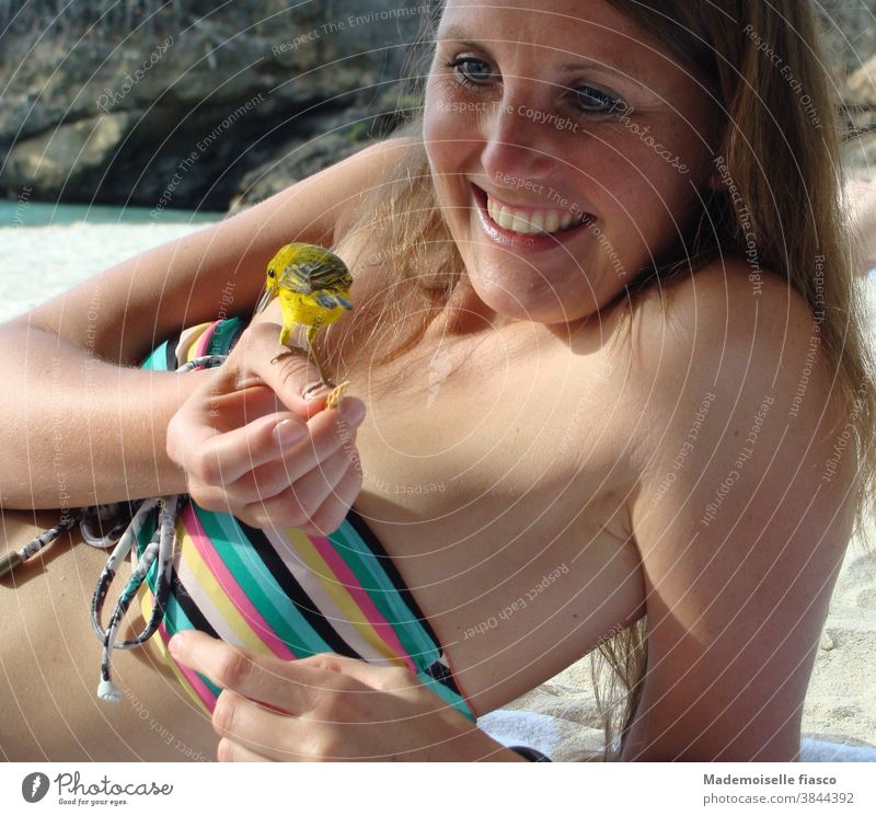 Vogel sitzt auf Hand von Frau am Strand Bikini Junge Frau Ferien & Urlaub & Reisen Karibik Sommerurlaub Sonnenlicht Haut feminin Freude Außenaufnahme