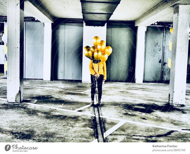 Goldene Luftballons gelb Ballons Farbfoto Farbe Tiefgarage grau weiß schwarz gold gelbe Jacke schwarze Hose unterirdisch Linie Parkhaus parken Kunst stehen