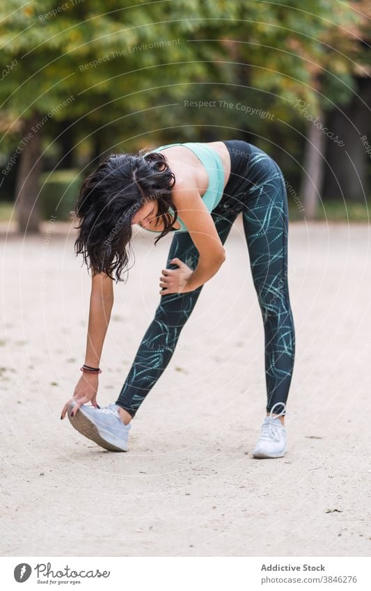 Fröhliche Sportlerin beim Aufwärmen während des Trainings Übung Dehnung Frau Park beweglich schlank Athlet passen Sportbekleidung Wellness Wohlbefinden Körper