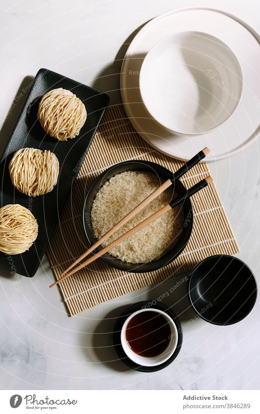 Asiatische Gerichte auf dem Tisch angeordnet Asiatische Küche Nudel Orientalisch Essstäbchen Soja Saucen Bambus Unterlage trocknen Reis Tradition