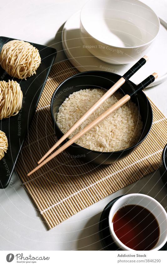 Asiatische Gerichte auf dem Tisch angeordnet Asiatische Küche Nudel Orientalisch Essstäbchen Soja Saucen Bambus Unterlage trocknen Reis Tradition