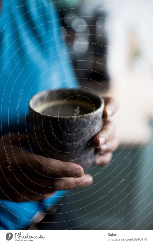 Frau in Blau hält einen individuellen Becher aus Ton mit Kaffee in der Hand Espresso Café genießen trinken Kaffeetasse Kaffeepause Farbfoto heiß lecker