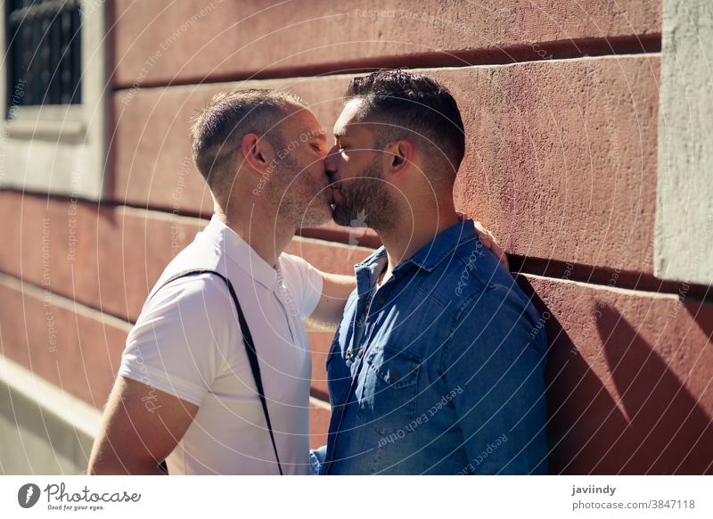 Schwules Paar küsst sich im städtischen Hintergrund im Freien. schwul Kuss Männer Küssen männlich Liebe Homosexualität lgbt lgbtq Partnerschaft Liebespaar