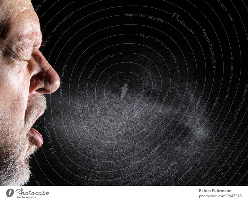Ein Mann versprüht beim Sprechen Aerosole in die Luft. Air luftgestützt Aufmerksamkeit Hintergrund Bakterien Vollbart schwarz Korona Coronavirus covid-19