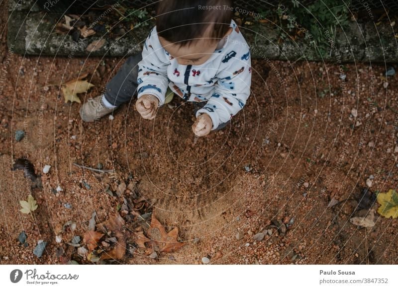 Kleinkind spielt im Park mit Sand authentisch Bodenbelag Kind Kinderspiel Kindheit Natur Neugier Fröhlichkeit Mensch Freizeit & Hobby Lifestyle Außenaufnahme
