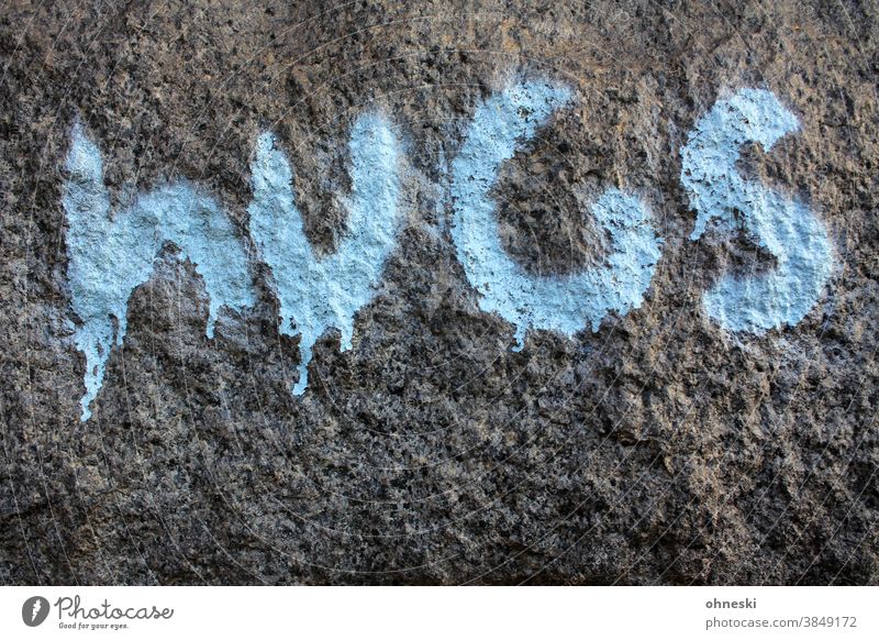 Graffiti "hugs" an einer Wand umarmung Typographie Tag hellblau Stein