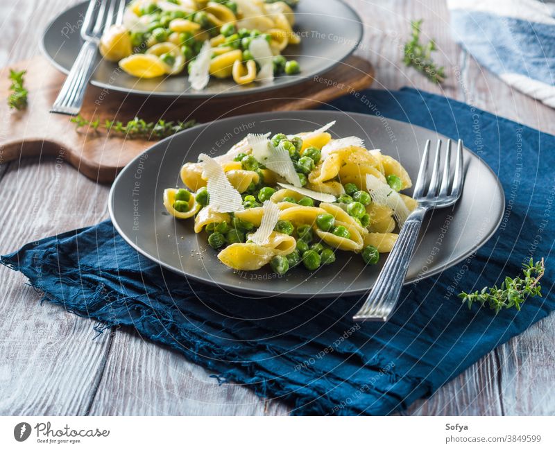 Italienische Orecchiette-Nudeln mit Erbsen und Käse Spätzle Lebensmittel italienische Küche Makkaroni Pecorino zerkleinern Gitter Gemüse Koch Speise Holztisch