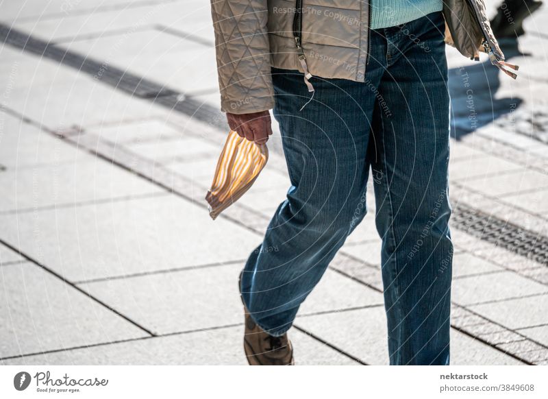 Person, die draußen die Maske in der Hand hält neue Normale Mundschutz mittlere Aufnahme Straße laufen Spaziergang Tag sonnig Frühling nicht erkennbare Personen
