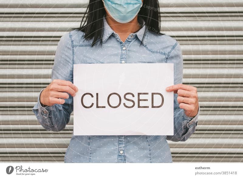 Coronavirus.Frau mit medizinischer Gesichtsmaske, die einen weißen Karton mit geschlossenem Text hält Chirurgische Schutzmaske Geschlossenes Geschäft Business