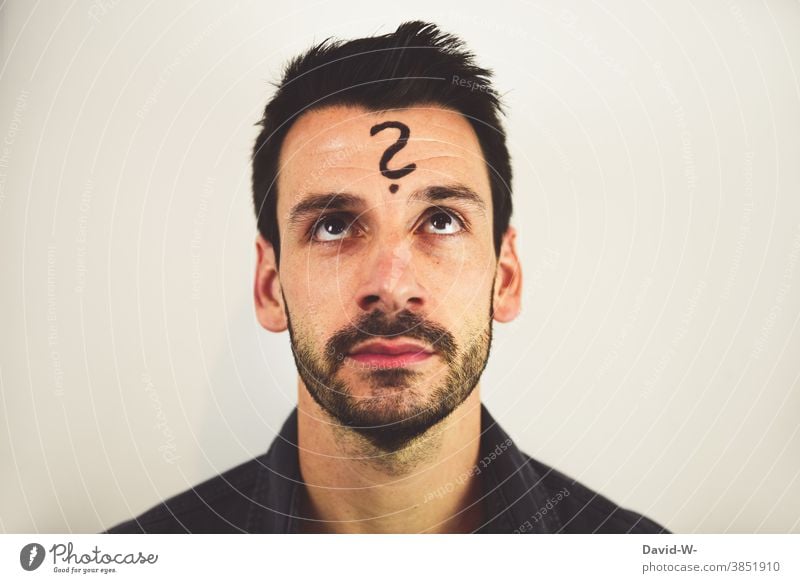 Mann mit Fragezeichen auf der Stirn nachdenklich ? denken nachdenken Fragender Blick unsicher Gedanken Zukunft