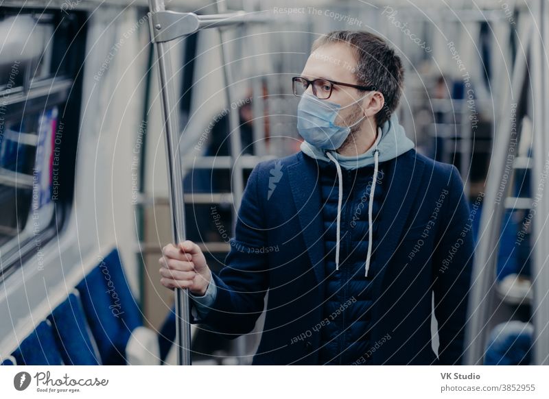 Prävention im öffentlichen Verkehr, Gesundheitsbewusstsein für den Pandemie-Schutz. Junger Mann trägt eine medizinische Maske, wenn er mit der S-Bahn reist, schützt sich vor Viren. Ausbruch von Covid-19 in Europa.