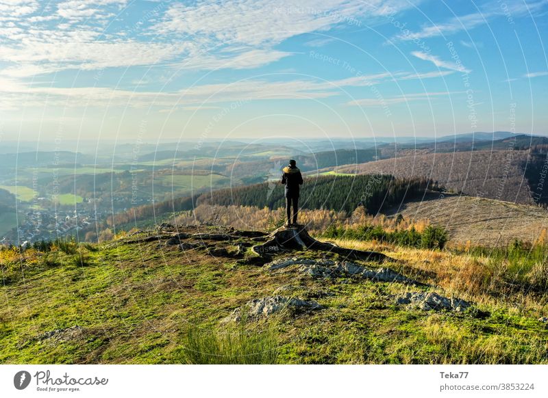 ein Mann, der im Winter auf einem Hügel in der Natur steht Stehen übersehen der Mensch in der Natur grün orange Wanderer wandern Ausblick