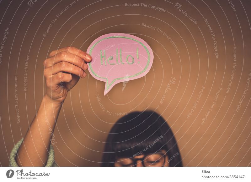 Frau mit Sprechblase auf der Hallo auf englisch geschrieben steht Begrüßung Fremdsprache Kommunizieren Hintergrund neutral Wort hello! halten Aufmerksamkeit
