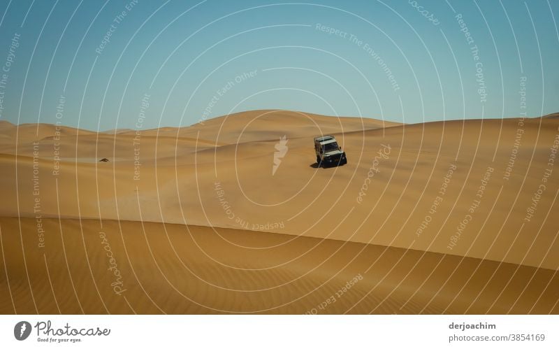 Auf Tour in den Dünen. Ein PKW fährt die Sand Düne hinunter. Blauer Himmel und keine Wolken. Namibia wüst Afrika Farbfoto Automobil Landschaft Natur heiß rot