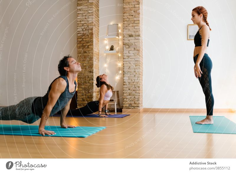 Mann und Frau tun Cobra Pose in der Nähe Lehrer Frauen Yoga Atelier üben Zen Dehnung Kobra-Pose Ausbilderin Zusammensein Trainerin Gesundheit Asana