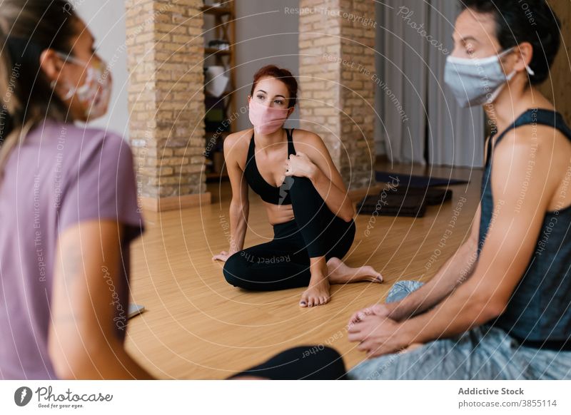 Menschen in Masken sprechen im Yoga-Studio Mann Frauen reden Atelier Pause Lektion Menschengruppe Pandemie Zusammensein diskutieren Gespräch Seuche COVID19