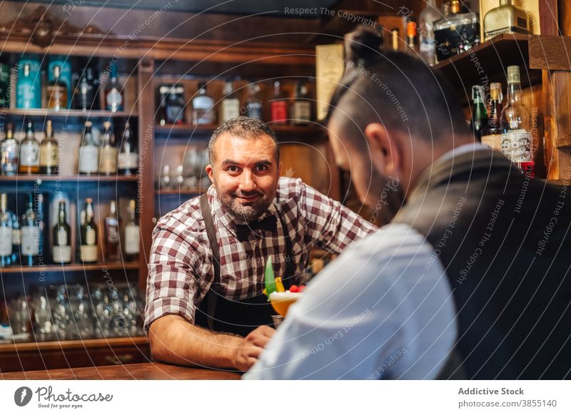 Barmann serviert Getränk an eleganten Kunden Männer Klient Cocktail dienen Abfertigungsschalter Alkohol Arbeit ruhen Barkeeper Club Kavalier trinken Restaurant