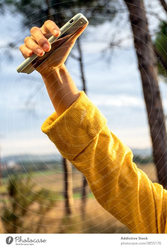 Anonyme Frau nimmt Selfie in Wiese im Herbst sich[Akk] entspannen Smartphone Selbstportrait Wochenende genießen Pullover gelb trocknen Feld Gerät Apparatur