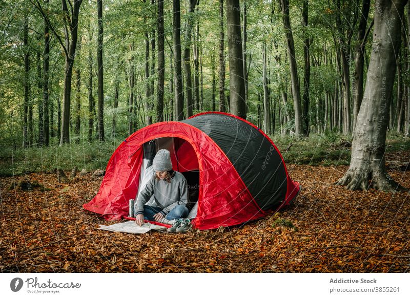 Frau lesen Papier Karte in der Nähe von Camping-Zelt Landkarte navigieren Campingplatz Lager Wald sich orientieren Suche Urlaub Natur Tourist erkunden