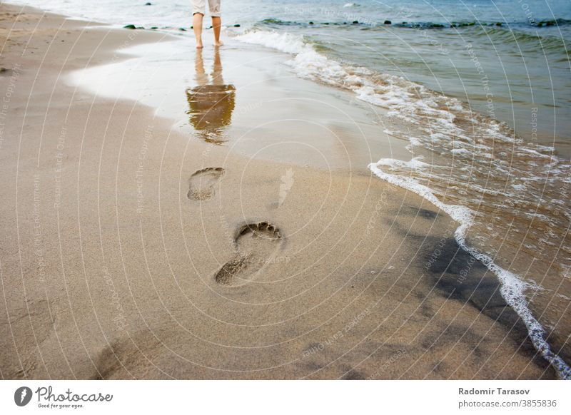 Fußabdrücke von Frauen am Meeresufer Bein Sand Wasser MEER Sommer Spaziergang Strand Küste winken Barfuß Lifestyle Person jung sich[Akk] entspannen Menschen