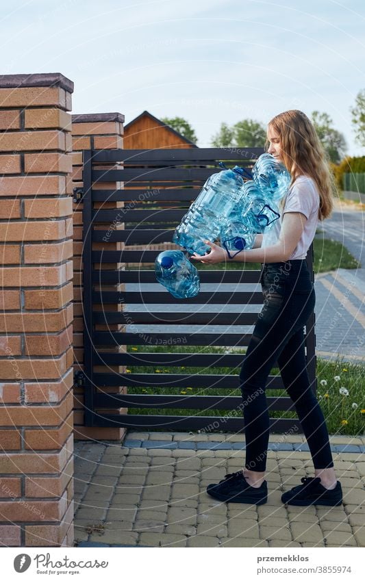 Junge Frau wirft leere gebrauchte Plastik-Wasserflaschen in den Mülleimer Behälter blau Flasche abholen sammelnd Container zerdrückt Entsorgung Ökologie Umwelt