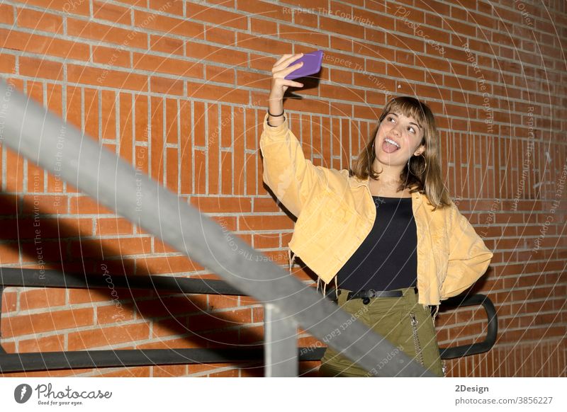 Schöne junge, stilvolle Frau, die mit einem modernen Smartphone durch die nächtlichen Straßen der Stadt läuft. Person Telefon Nacht Mobile Technik & Technologie