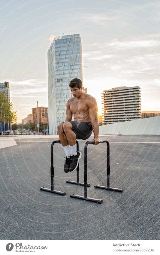 Shirtless Sportler arbeiten auf Bars in der Stadt Übung Training muskulös ohne Hemd Gleichgewicht passen professionell Ausdauer Großstadt Straßenbelag Mann
