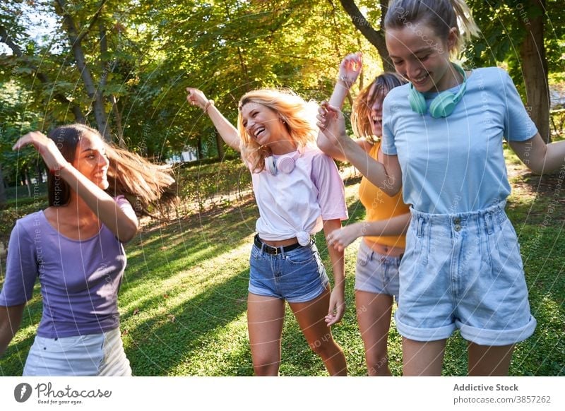Erfreuliche diverse Freundinnen haben Spaß im Park Spaß haben Tanzen sich[Akk] sammeln Sommer Glück heiter Zusammensein Teenager rassenübergreifend