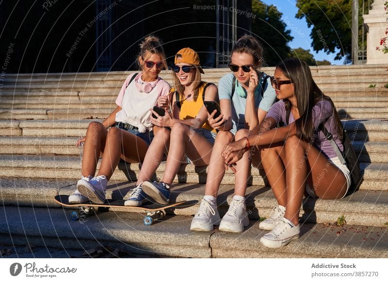 Gruppe von Teenagern mit Smartphones sitzen auf Stufen in der Stadt Freundin urban Zusammensein heiter benutzend trendy Mobile Schritt Frauen jung
