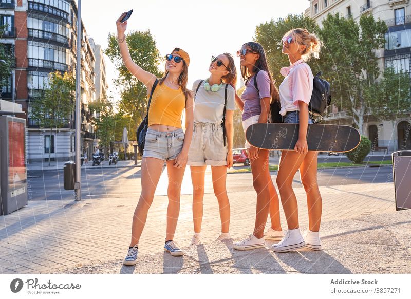 Positive weibliche Teenager nehmen Selfie in der Stadt Freundin urban Sommer Glück trendy heiter Zusammensein Menschengruppe Mädchen Skateboard aktiv Telefon