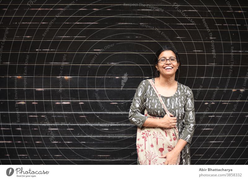 Porträt einer indisch-bengalischen brünetten Frau vor einer Wand/Metallic-Tor/ schwarz strukturierter Hintergrund. Indischer Lebensstil Schauspielerin