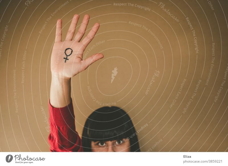 Frauenpower. Frau hält ihre Hand, auf die das Venussymbol gemalt ist, hoch. Emanzipation und Feminismus. Symbol weiblich Gleichstellung Kraft Kampf Mensch