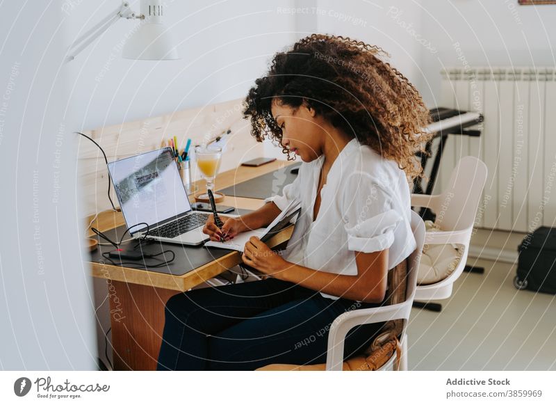 Ethnische Frau, die von zu Hause aus arbeitet Arbeit abgelegen freiberuflich Laptop zur Kenntnis nehmen schreiben modern Planer jung Afroamerikaner schwarz