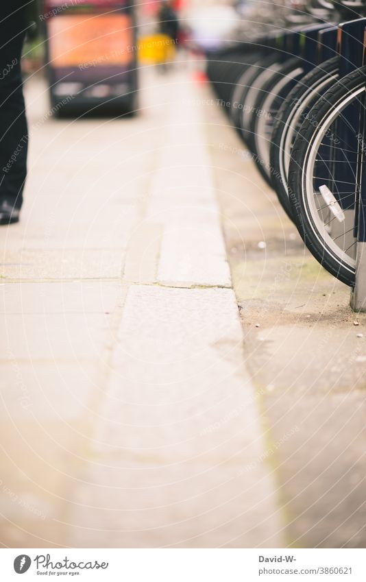 Fahrräder in in Reih und Glied am Straßenrand Räder Reihe abgestellt verleih Stadt Ordnung Fahrradfahren Fahrradständer parken Verkehrsmittel