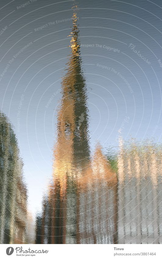 Spiegelung eines Kirchturms und Häuser im Wasser Reflexion & Spiegelung Meer Fluss See Stadt Häuserzeile krumm Verzerrung surreal Schönes Wetter Kirchturmspitze