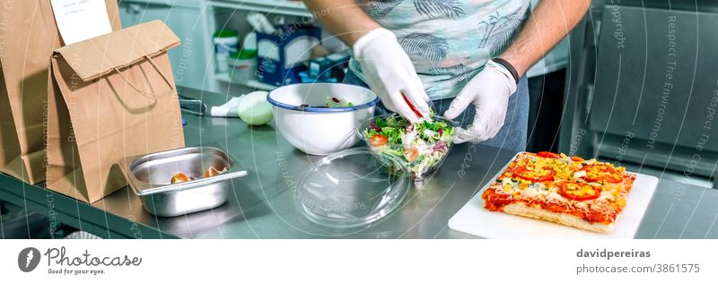 Unbekannter Koch bereitet Takeaway-Bestellungen vor unkenntlich Küchenchef Bestellungen vorbereiten Imbissbude Salatbeilage Großküche Paket Handschuhe Hygiene