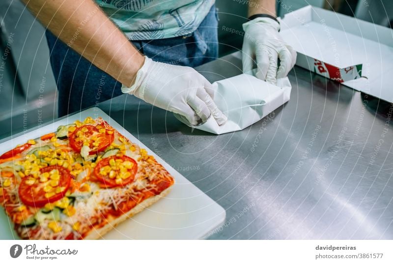 Unbekannter Koch verpackt Takeaway-Bestellungen Imbissbude unkenntlich Bestellungen vorbereiten Verpackung Handschuhe Hygiene sichere Lebensmittel Gemüse-Pizza