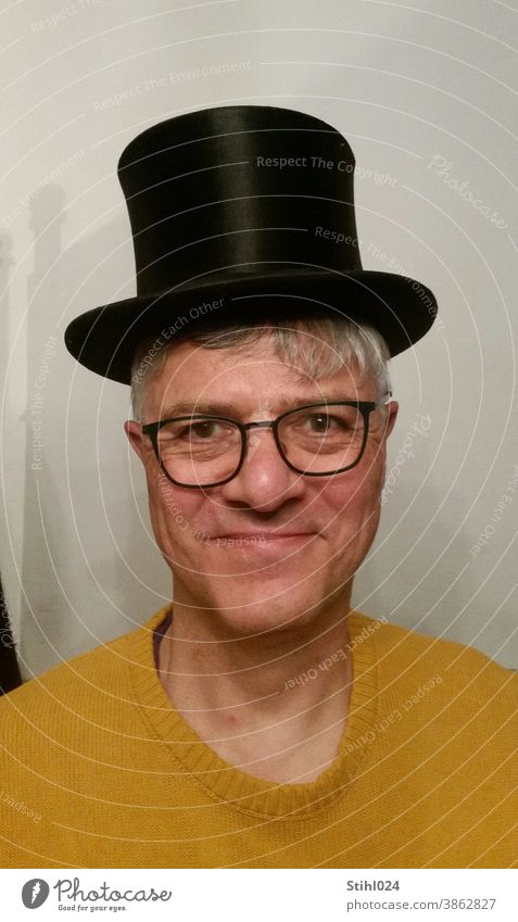 Chapeau! - Mann in den Fünfizigern mit schwarzem Zylinder Hut MAnn Pullover gelb senfgelb Brille LAchen Spaß Zirkus Theater klassisch förmlich formell festlich