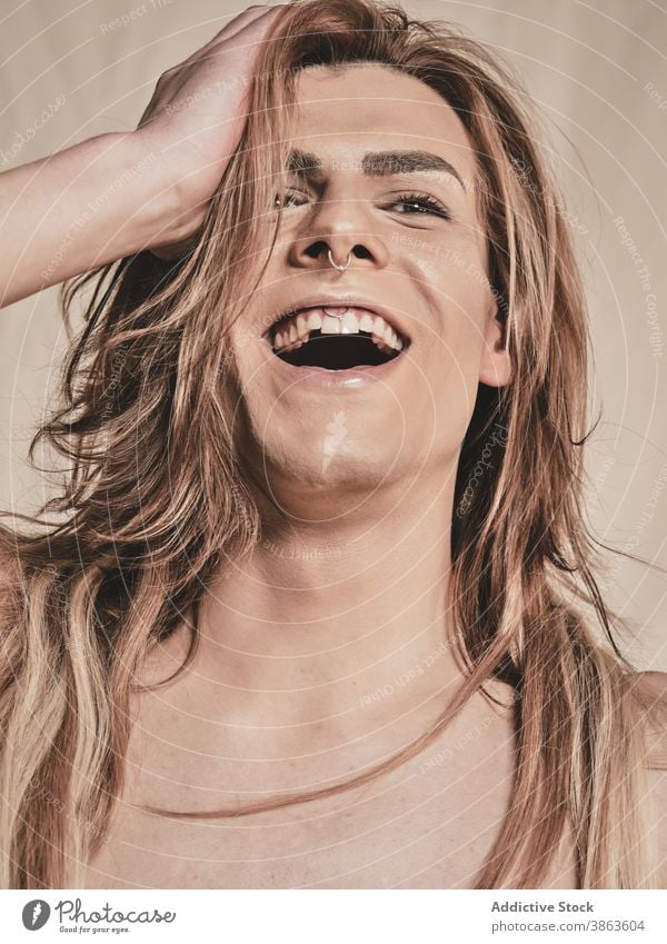 Junger hemdloser androgyner Mann lachend Lachen Make-up ohne Hemd Vorschein Transgender Glück Model jung männlich Stirnband Piercing aufgeregt queer lgbtq
