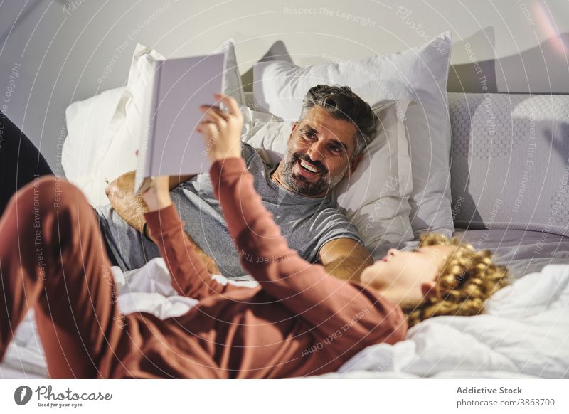 Vater und Sohn lesen gemeinsam ein Buch Vaterschaft Kinderbetreuung Zusammensein Bett märchenhaft Abend interessant Kälte Etage Liebe sich[Akk] entspannen