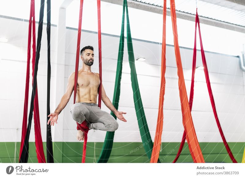 Shirtless Turner meditieren auf Stoff Mann Antenne Gewebe Seide Bändchen Atelier hängen Tänzer üben Gleichgewicht männlich ohne Hemd muskulös Choreographie
