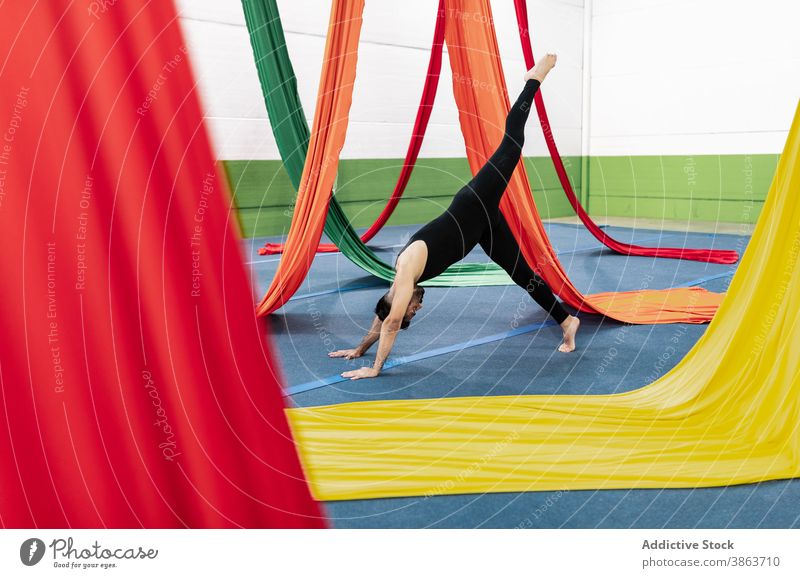 Barfuß Mann übt in der Nähe von Luftseiden Tänzer Übung gymnastisch Antenne Seide Trikot Gleichgewicht Probe üben männlich Turner Stock Stoff farbenfroh Tanzen