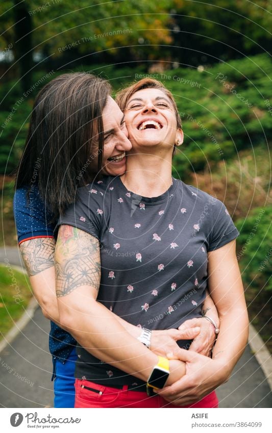 Lachendes lesbisches Paar mittleren Alters umarmt sich im Freien lgbtq schwul mittleres Alter 40 50 umarmend Beteiligung Umarmen Lächeln Homosexualität Frauen
