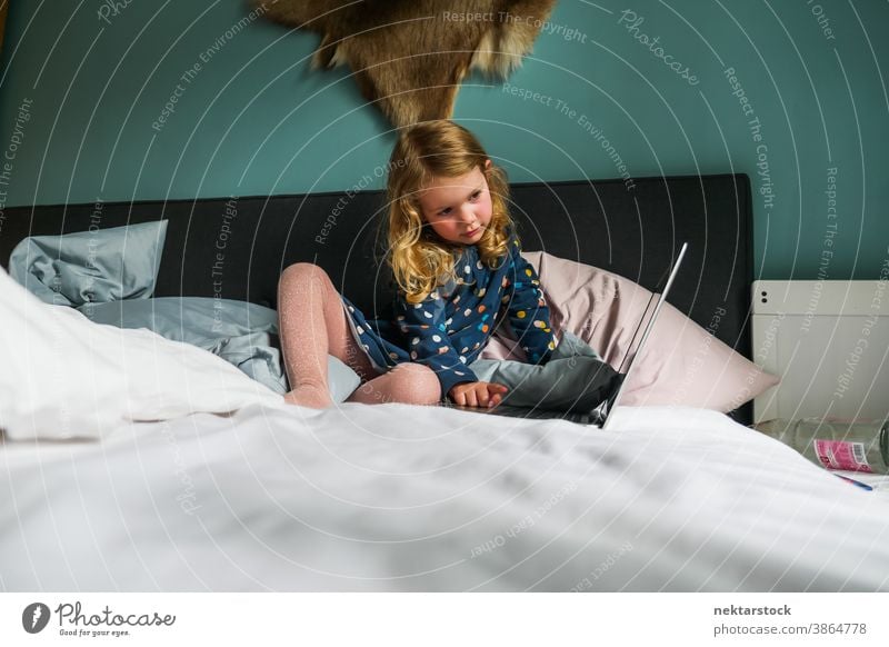 Kleines kaukasisches Mädchen benutzt Laptop im Bett Kind Kaukasier Computer blond 5 Jahre alt Totale reales Leben echte Person Lifestyle häusliches Leben Frau