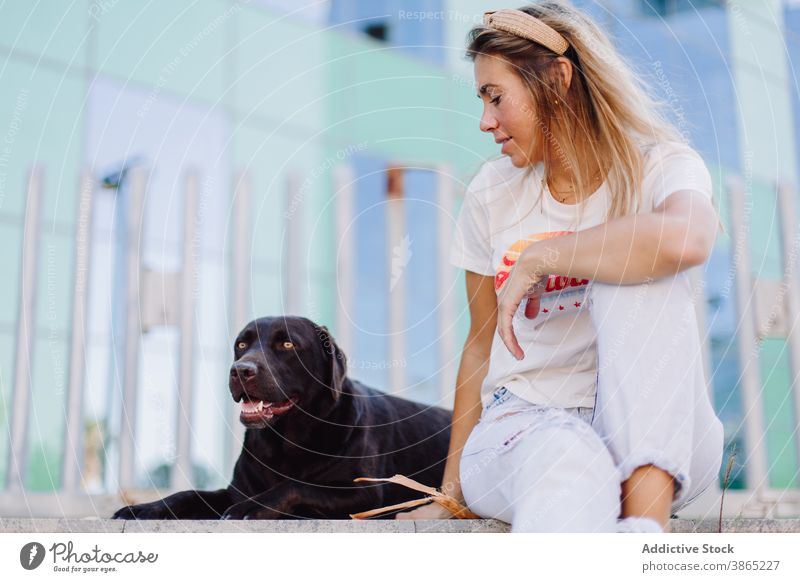 Fröhliche Frau mit schwarzem Hund in der Stadt Großstadt Freundschaft gehorsam labrador retriever sich[Akk] entspannen Bank Sommer Tier Haustier heimisch