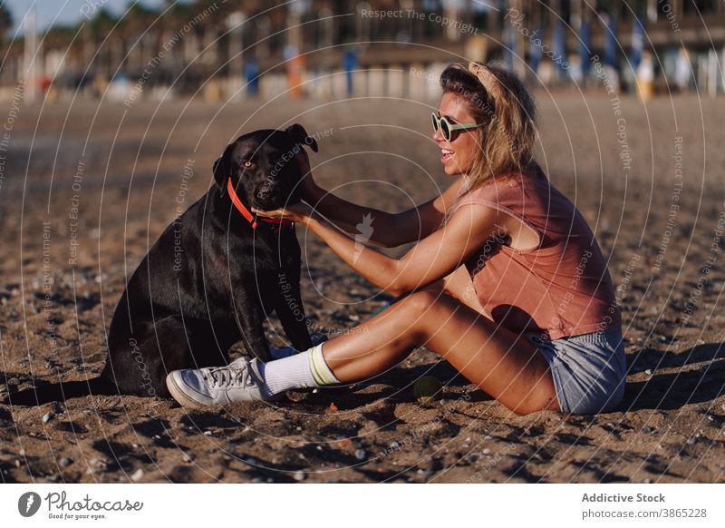 Frau mit süßem Hund am Strand Sonnenuntergang sorgenfrei Kraulen Zusammensein Meeresufer Freundschaft labrador retriever Ufer bezaubernd schwarz Tier Haustier