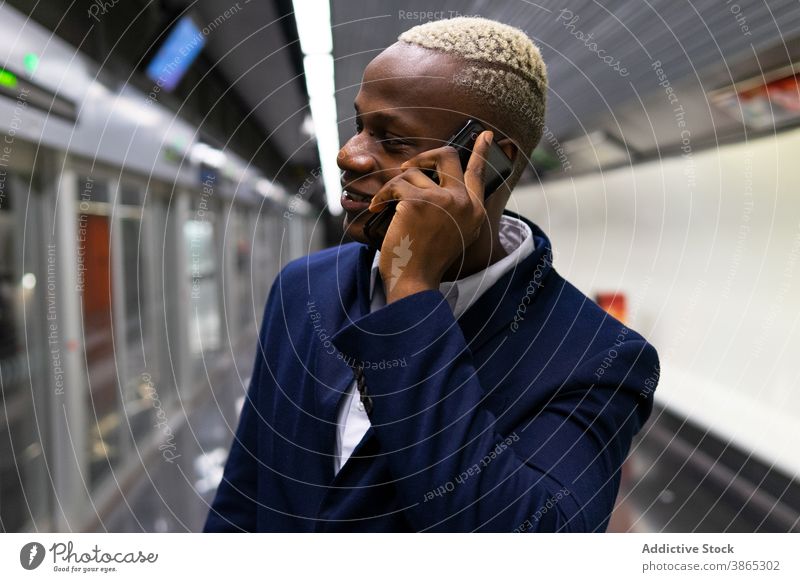Schwarzer Geschäftsmann spricht mit Smartphone in der U-Bahn Arbeitsweg unterirdisch reden Unternehmer sprechen benutzend männlich ethnisch schwarz