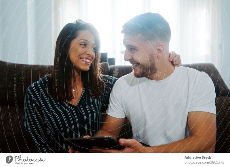 Paar verwendet Tablet zusammen Tablette Lächeln Browsen Gerät Apparatur Zusammensein Surfen online benutzend heimwärts Wochenende soziale Netzwerke