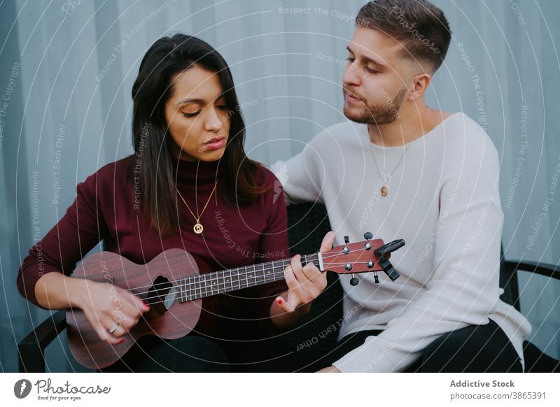 Paar spielt Ukulele auf der Terrasse eines kompakten Hauses Hinterhof Veranstaltung sich[Akk] entspannen Container Musik Zusammensein ruhig Partnerschaft Gesang