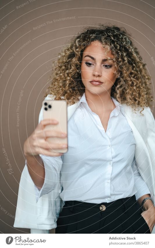 Charmante Frau nimmt Selfie auf Smartphone Lächeln Glück Selbstportrait Gesicht machen Lippe Atelier charmant Telefon Stil Zeitgenosse trendy Apparatur Gerät